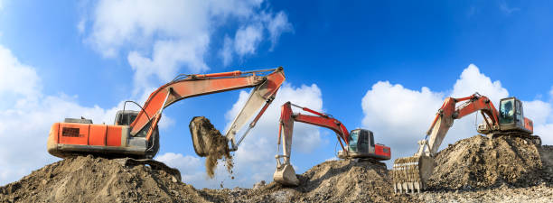 istock Three excavators working at building site on sunny day 1080118722