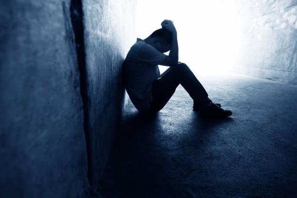 uomo disperato seduto nel tunnel - adult loneliness depression foto e immagini stock