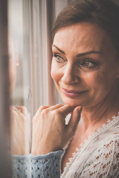 istock Aspiring woman looking trough the window 1080123138