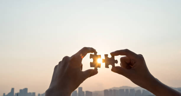istock Woman hand putting puzzle pieces together in sunset 1080129774
