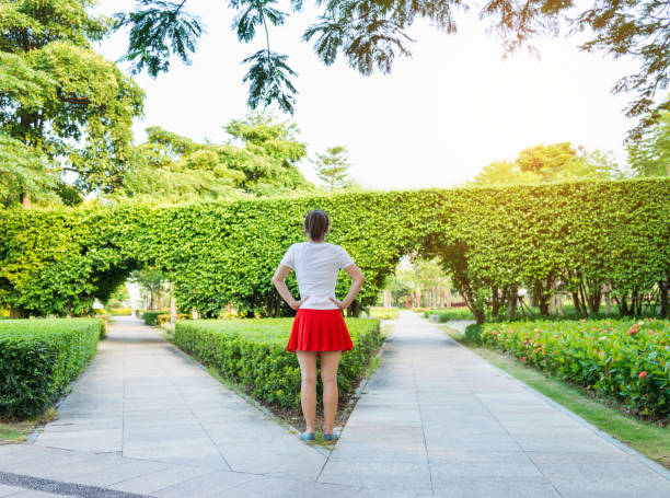 woman standing in front of forked road - women rear view one person arch imagens e fotografias de stock