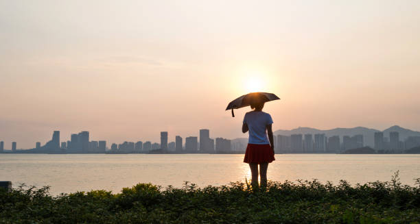 istock Woman standing on beach in sunset 1080131482