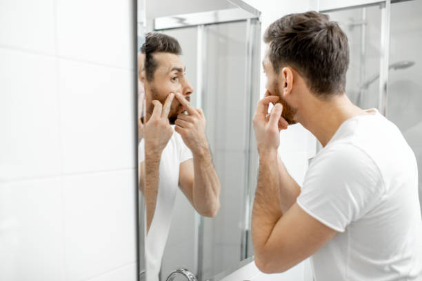 istock Man squeezing acne in the bathroom 1080139500