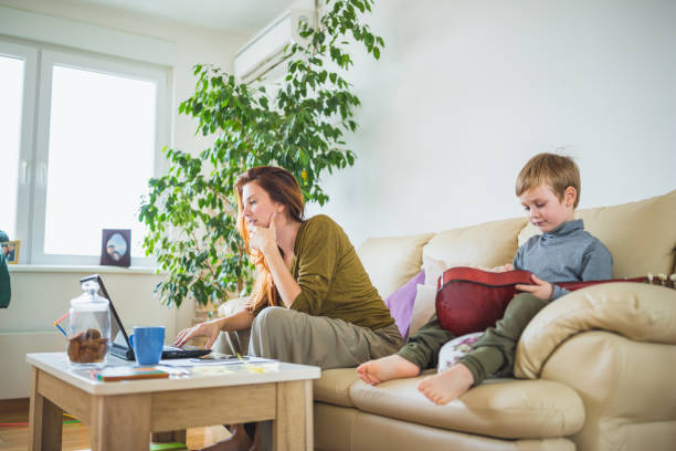 istock Pregnant woman working from home, while her son is playing 1080146676