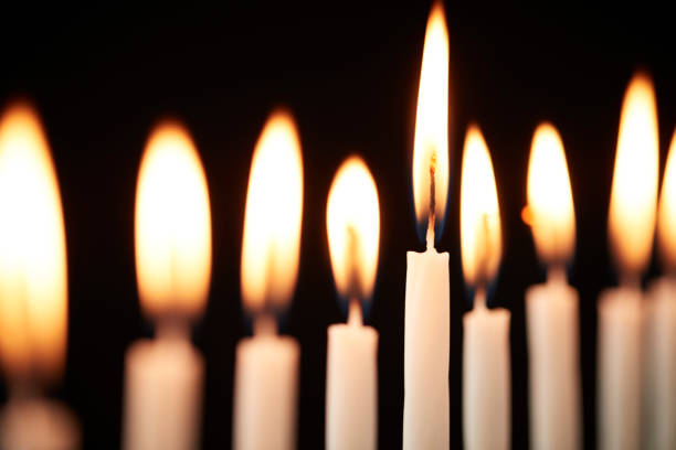 Close Up Of Lit Candles On Metal Hanukkah Menorah Against Black Studio Background Close Up Of Lit Candles On Metal Hanukkah Menorah Against Black Studio Background hanukkah candles stock pictures, royalty-free photos & images