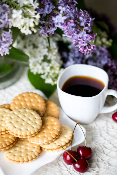 istock Spring season. Mood. Flowering lilac. Coffee and biscuits with cherries. 1080150176