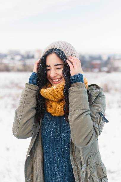 istock Smiling woman feeling cold snowflakes on her face during a snow 1080154060