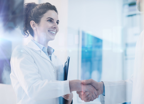 Young female practitioner shaking hands with a doctor, career and healthcare professionals concept