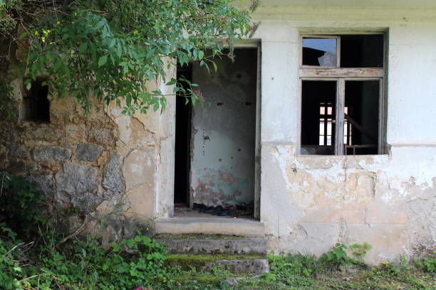 istock Empty wooden door frame with missing doors on abandoned dilapidated stone house 1080157970