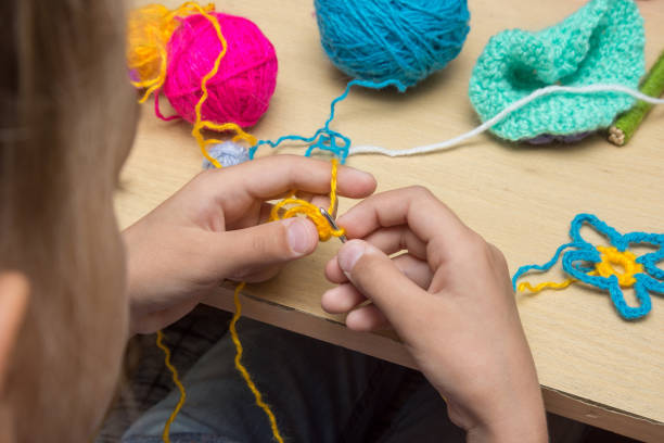 istock Hands of a child are embroidered with threads using a hook 1080159662