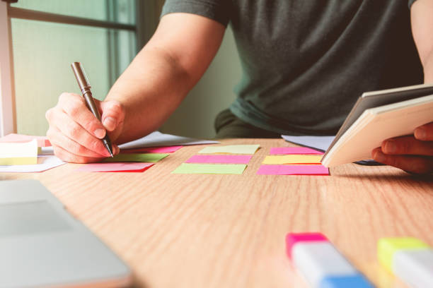 istock New. Business man holding pen meeting at home office and using notes paper share design planning ,brainstorming brainstorm idea on desktop 1080161566