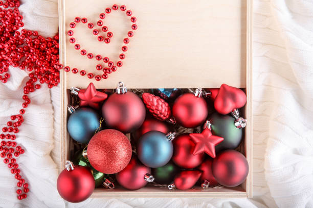 Christmas tree ornaments in wooden box on white background. Box filled with New Year decorations. Top view. Copy space. Christmas tree ornaments in wooden box on white background. Box filled with New Year decorations. Top view. Copy space. christmas decoration storage stock pictures, royalty-free photos & images