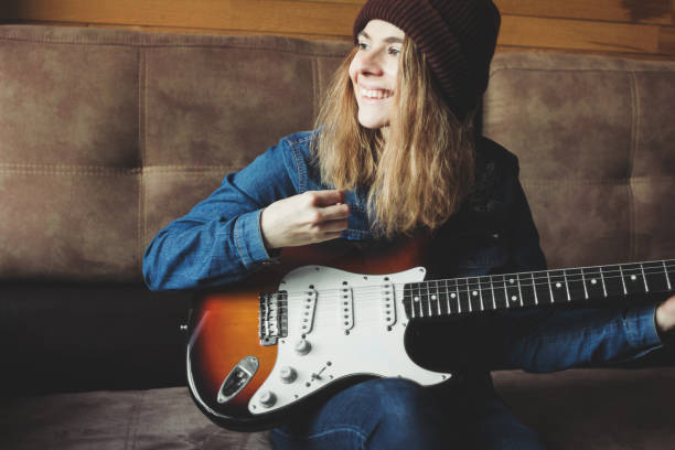 istock Young woman playing electric guitar and smiling 1080167294