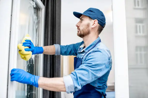 Photo of Man as a professional cleaner washing window