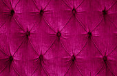 Close-up of a dark magenta quilted velvet sofa with upholstered buttons (diamond stitching) / Rautenheftung