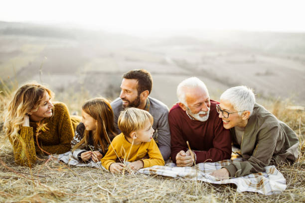 istock Happy extended family talking while relaxing on the field. 1080180516