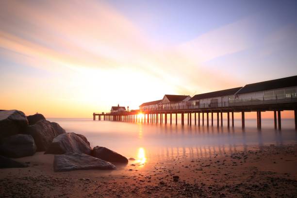 A long exposure photo of an early morning sunrise at Southwold Pier in Suffolk, England. A long exposure photo of an early morning sunrise at Southwold Pier in Suffolk, England. southwold stock pictures, royalty-free photos & images