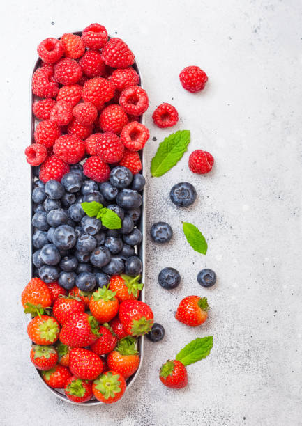 istock Fresh raw organic berries in in stainless steel tray on kitchen table background. Space for text. Top view. Strawberry, Raspberry, Blueberry and Mint leaf 1080185780