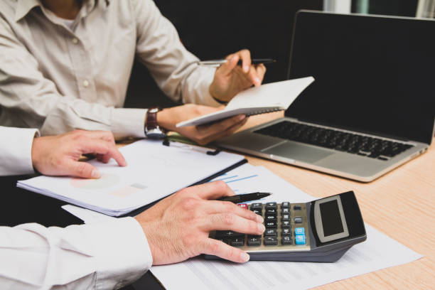 istock Group businessman hand using calculator Calculating bonus(Or other compensation) to employees to increase productivity.Writing paper on desk. 1080189046
