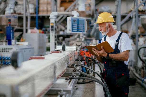 Senior factory worker Senior factory worker. Shadow DOF. Developed from RAW; retouched with special care and attention; Small amount of grain added for best final impression. 16 bit Adobe RGB color profile. machine stock pictures, royalty-free photos & images
