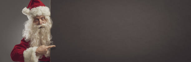 istock Happy Santa pointing at a blank sign 1080199222