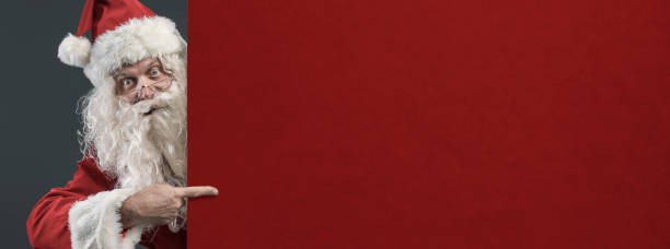 istock Happy Santa pointing at a blank sign 1080199280
