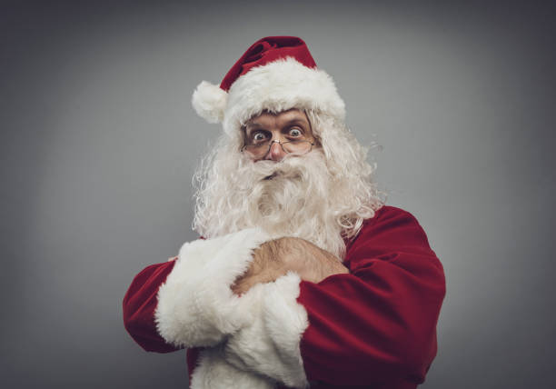 Confident funny Santa Claus posing with arms crossed and looking at camera, Christmas character