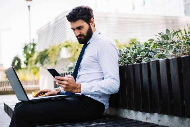 istock Businessman On Park Bench With Coffee Using Mobile Phone and Lap Top 1080210178
