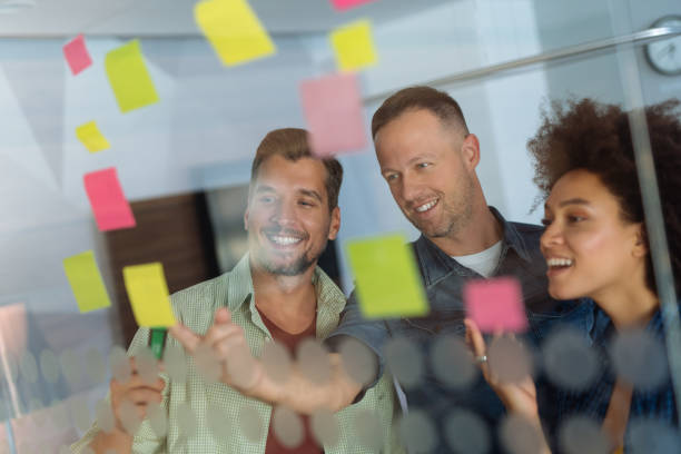 istock Coworkers discussing new ideas on a glass wall 1080211482