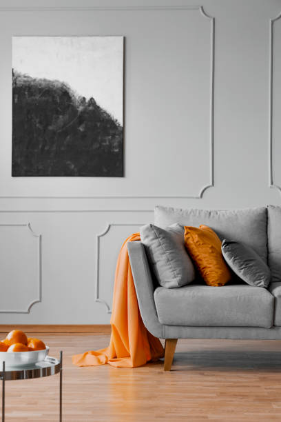 istock Silver table near sofa with pillows and blanket in grey apartment interior with poster. Real photo 1080213788