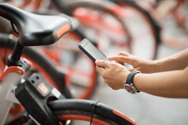 mãos de pessoas usando smartphone digitalizar o código qr de bicicleta compartilhada na cidade - bikeshare - fotografias e filmes do acervo