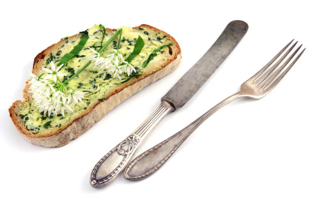 dark bread with wild garlic butter. antique silverware on white background