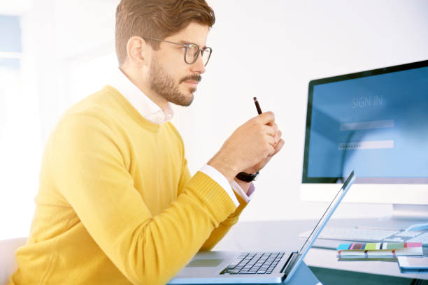 istock Young businessman looking thoughtfully while working on notebook in the office 1080218726