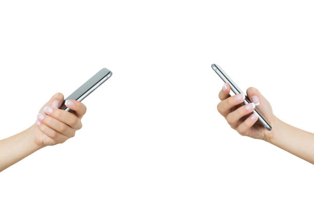 due mani che tengono i telefoni cellulari su sfondo bianco - women typing human hand computer key foto e immagini stock