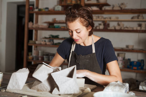 istock adult woman make pottery at table in workshop 1080224088