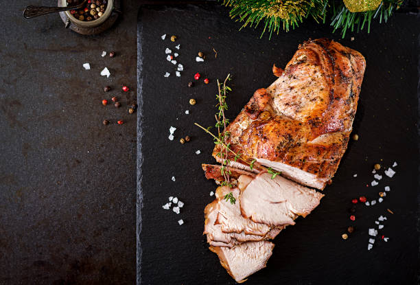 roasted sliced christmas ham of turkey on dark rustic background. top view. festival food. - christmas turkey imagens e fotografias de stock