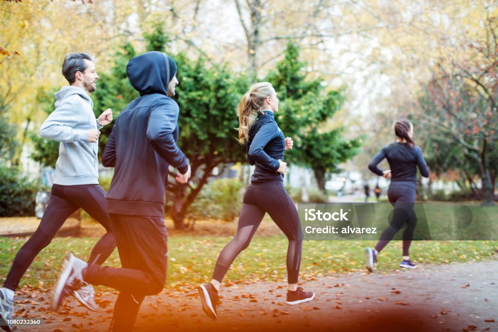 Kleine Gruppe von Menschen laufen im Herbst park - Lizenzfrei Rennen - Körperliche Aktivität Stock-Foto