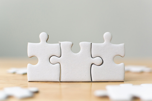White jigsaw puzzle connecting together. Team business success partnership or teamwork concept