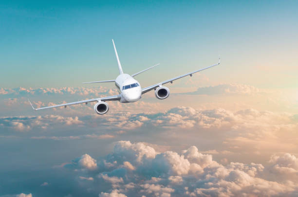 istock Passenger airplane flying above overcast clouds green pink gradient sky 1080252372