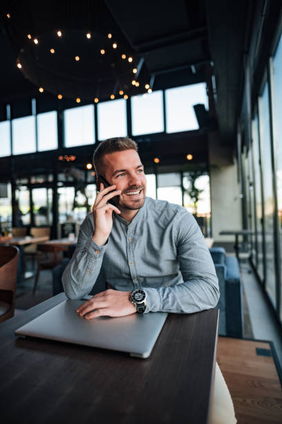 istock Young entrepreneur talking over mobile phone in modern cafe. 1080258132