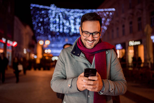 istock Handsome man texting at decorated city street at night. Front view. 1080258596