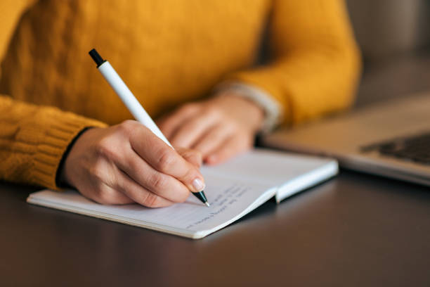 écrire dans cahier. gros plan. - author photos et images de collection