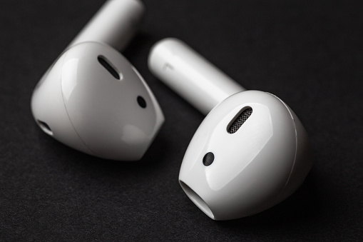 White wireless bluetooth earphones or headphones, macro photo close up