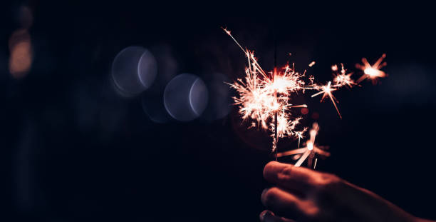 istock Hand holding burning Sparkler blast on a black bokeh background at night,holiday celebration event party,dark vintage tone. 1080262558