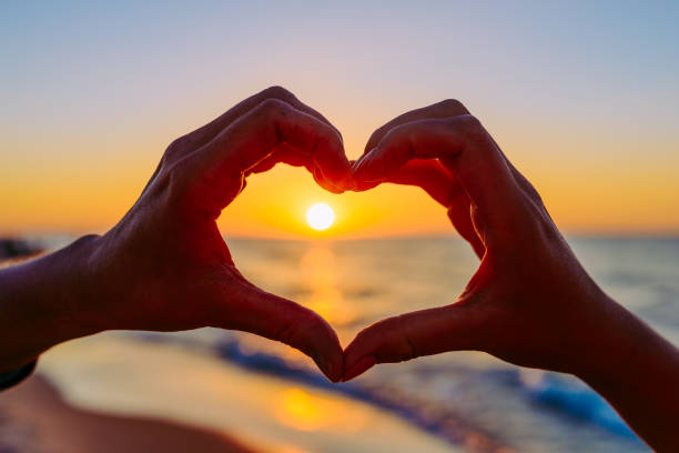 istock hands forming a heart shape with sunset silhouette 1080282434