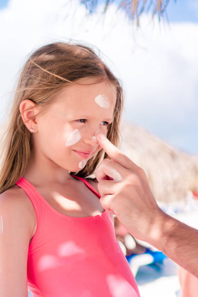 istock Father applying sun cream to daughter nose. 1080288442