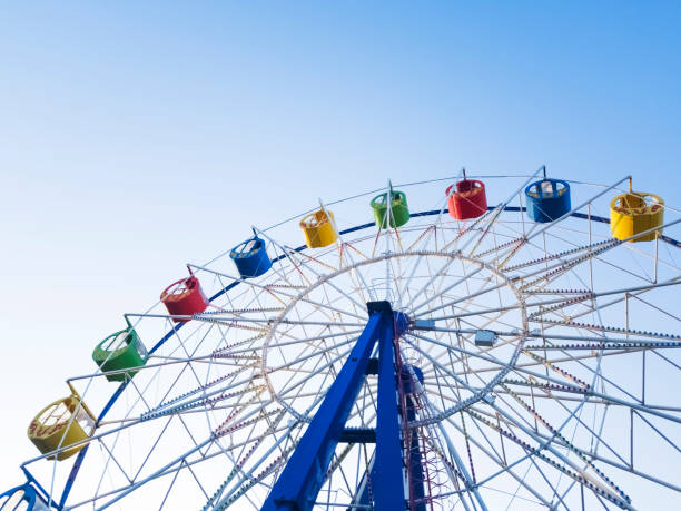 istock Underside view of a ferris wheel over blue sky 1080290542