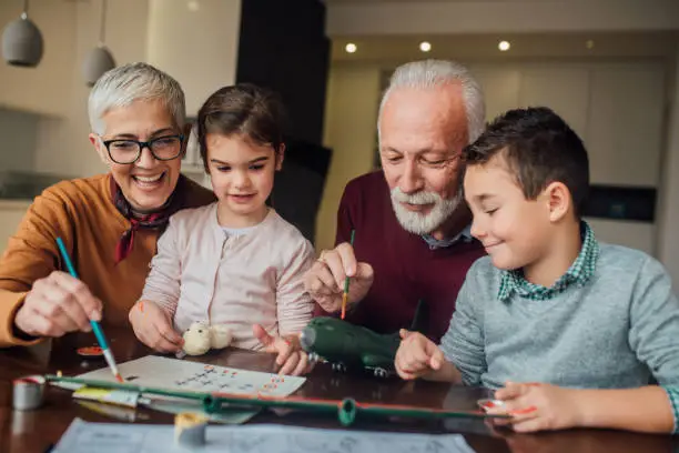 Photo of Joyful family crafting a toy