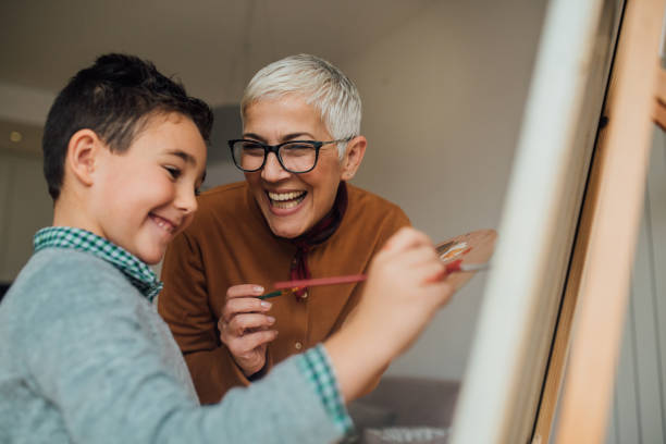 femme, aider le jeune garçon dans la peinture sur toile - artist child artists canvas indoors photos et images de collection