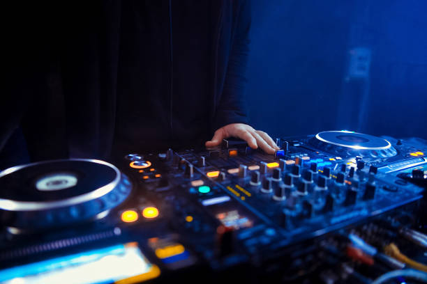 istock DJ turntable console mixer controlling with two hand in concert nightclub stage. 1080293564